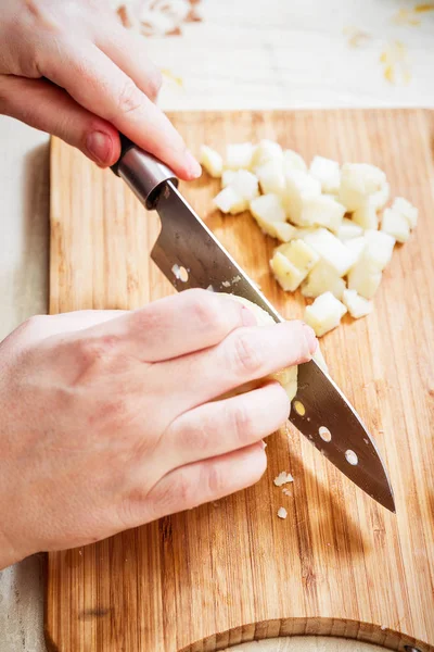 Tangan womans dengan pisau memotong kentang mendidih — Stok Foto