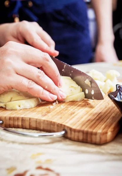 Womans hand with a knife cutting the boiling potatoes — Stock Photo, Image