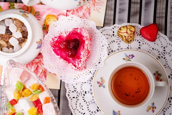 Porcelain cup of tea with lemon and sweets — Stock Photo, Image