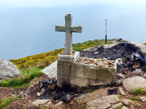 Cross and fireplace on Cape Fisterra (Galicia, Spain). — Stock Photo, Image