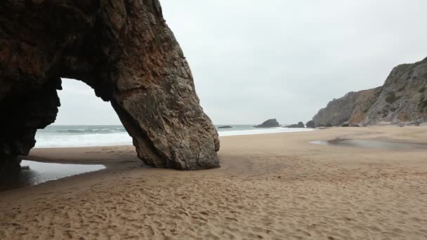 Sandy beach ve rock arch, Portekiz. — Stok video