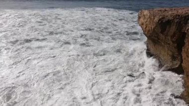 Kayalık sahilde dalgalar kopuyor.