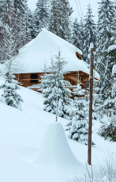 Casa de madera en pendiente de invierno . — Foto de Stock