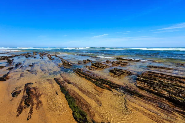 Rock formations on sandy beach (Portugal). — Stock Photo, Image