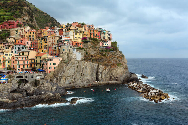 Beautiful summer Manarola - one of five famous villages of Cinque Terre National Park in Liguria, Italy, suspended between Ligurian sea and land on sheer cliffs. People and signs unrecognizable.