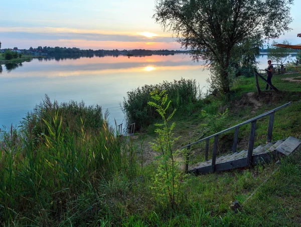 Gelukkige vrouw op kampeerplaats op zonsondergang zomer meer rustig strand — Stockfoto