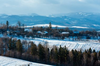 Alan ve köy ile kış dağ manzarası.