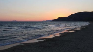 Güzel, yatay, tropikal deniz günbatımı kum plajındaki pitoresk (Gaeta, Latina, İtalya). Tanınmayan insanlar çift eğlenceli banyo ve ileri Yüzme.
