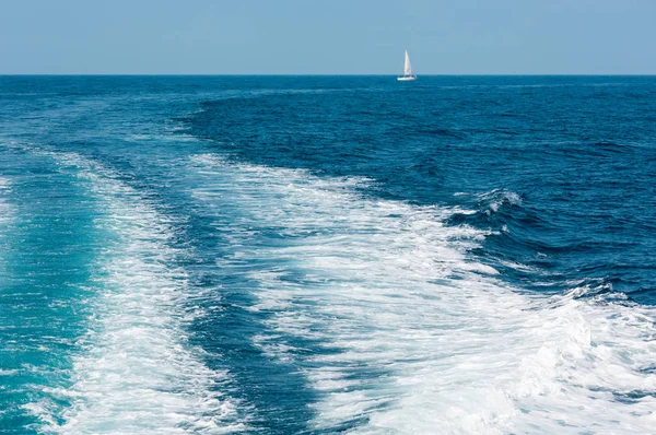 海の水面上をトレースし、遠くの船をセーリング — ストック写真