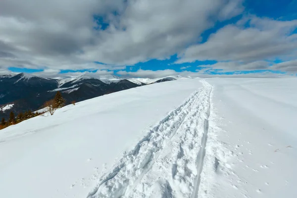 そりトレースと冬の山の丘の上の足跡 — ストック写真