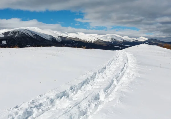 Huellas de trineo y huellas en la cima de la colina de invierno — Foto de Stock