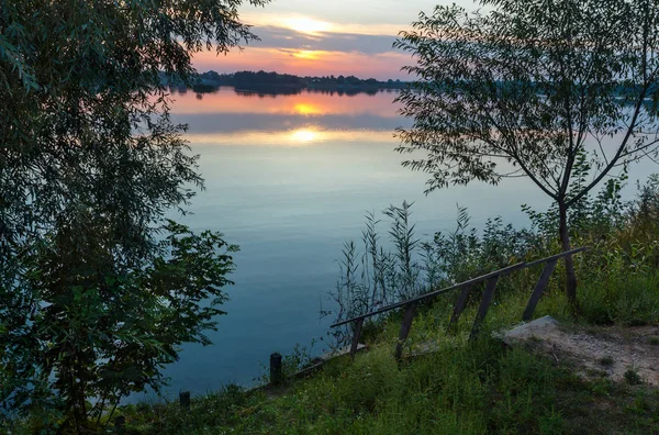 Houten trap naar de zomer zonsondergang lake — Stockfoto