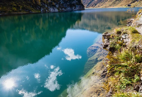 Zonnige herfst alpine Tappenkarsee meer en rotsachtige bergen boven, — Stockfoto