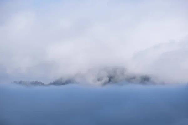 Fluffiga moln på kvällen mulen himmel utsikt. Bergstoppar silhou — Stockfoto