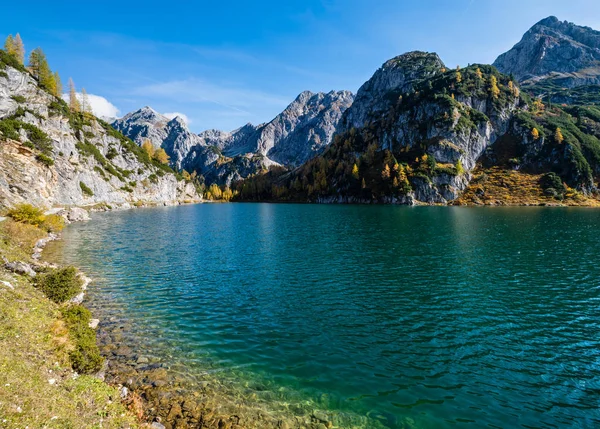 Zonnige herfst alpine Tappenkarsee meer en rotsachtige bergen boven, — Stockfoto