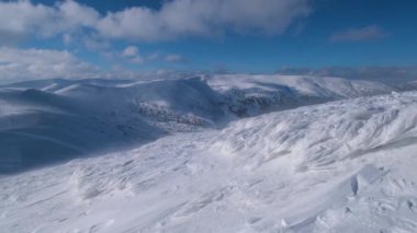 Dağ bulutlu ve rüzgarlı bir manzara. Kayak merkezi Dragobrat, Karpatya dağları, Ukrayna. Şiddetli rüzgar yüzünden hafif bir kamera seğirmesi var.. 