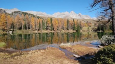 Autumn alpine mountain lake near San Pellegrino Pass, Trentino, Dolomites Alps, Italy. Picturesque traveling, seasonal and nature beauty concept scene.
