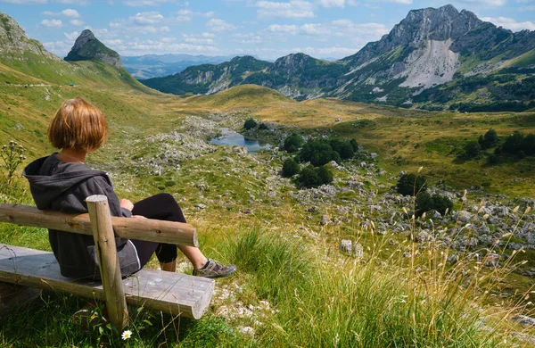坐在木制长椅上的妇女 以及黑山 巴尔干 迪纳罗克阿尔卑斯山国家公园 联合国教科文组织世界遗产的风景如画的夏季山景 Sedlo路 全景道 — 图库照片