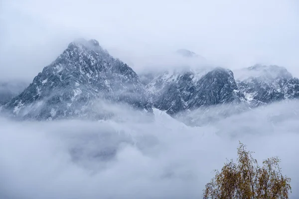 Sis Bulutlar Arasında Dağ Silueti Parçalarıyla Kaplı Bulutlu Bir Sonbahar — Stok fotoğraf