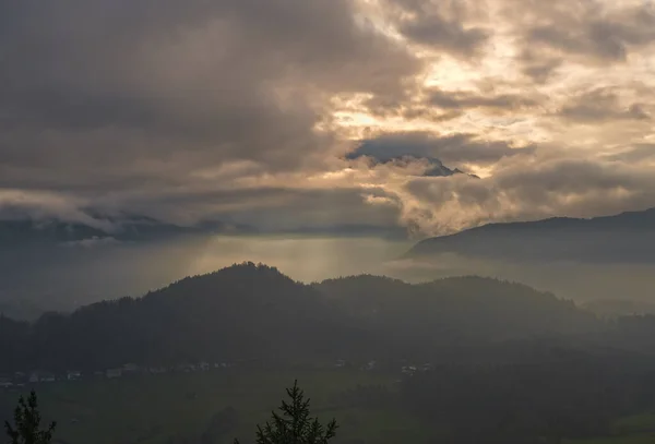 Autumn hazy day Berchtesgadener Land and mount Watzmann silhouette fragments in contra light cloudy view from Marxenhohe viewpoint, Bavarian prealps, Germany