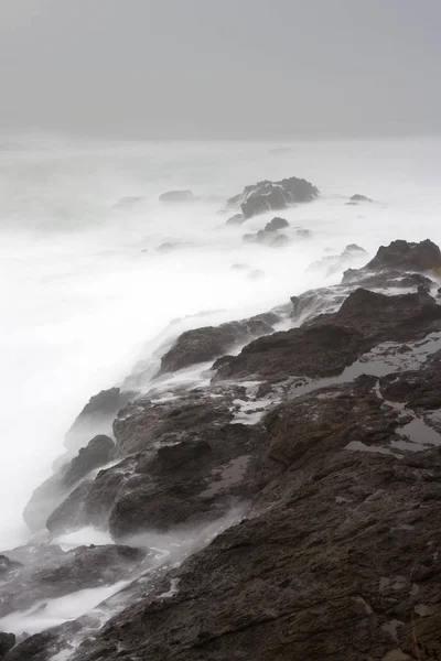 Silky waves crashing on the rocks — Stock Photo, Image