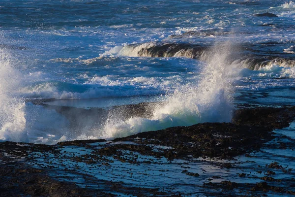 Хвилі розбиваються на лавових скельних блефах — стокове фото