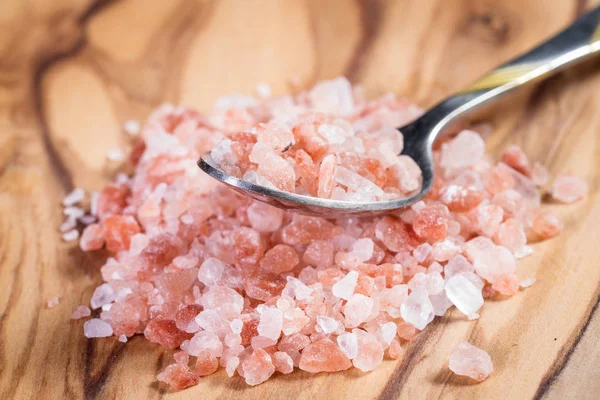 Гималайская розовая соль на ложке — стоковое фото