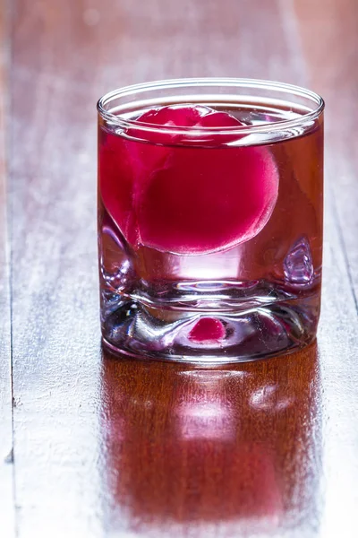 Червоний крижаний м'яч у напої — стокове фото