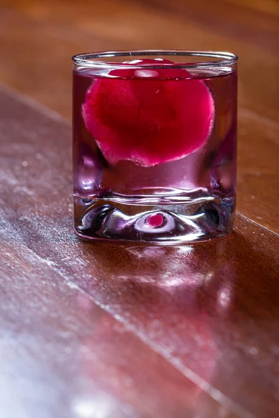Bola de gelo vermelho em uma bebida — Fotografia de Stock