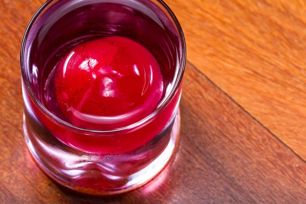 Bola de hielo rojo en una bebida —  Fotos de Stock