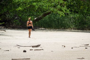 Kumsalda yürüyen bir turist. 