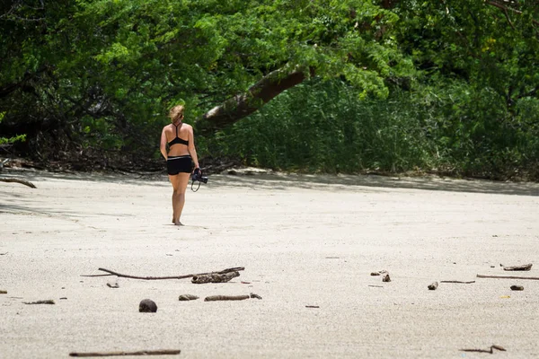 Kumsalda yürüyen bir turist. 