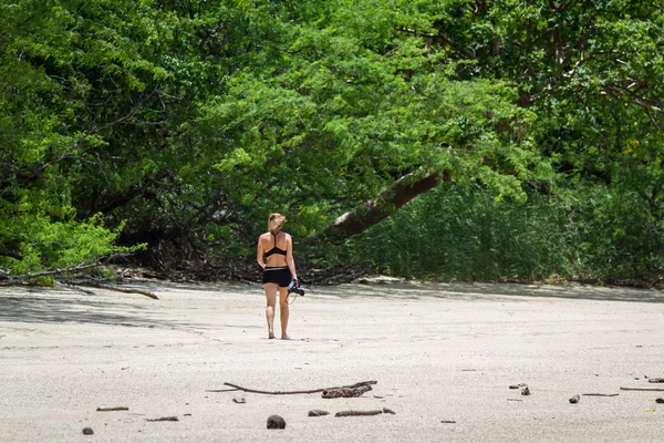 Kumsalda yürüyen bir turist. 