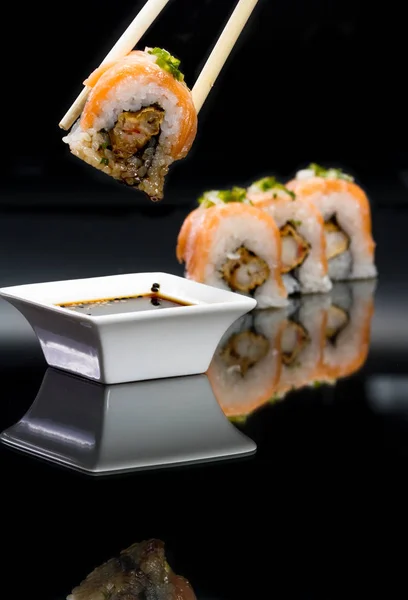 Sushi rolls over black — Stock Photo, Image