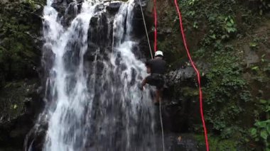 Adventure tourism in tropical Costa Rica while rappelling down a beautiful waterfall  deep in the southern mountains of the country
