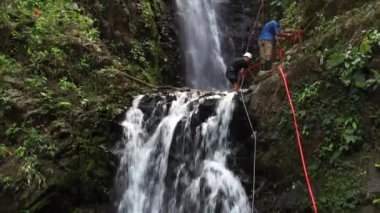 Adventure tourism in tropical Costa Rica while rappelling down a beautiful waterfall  deep in the southern mountains of the country