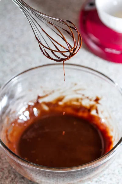 Perto Batedor Coberto Chocolate Escuro Com Uma Tigela Vidro Fundo — Fotografia de Stock