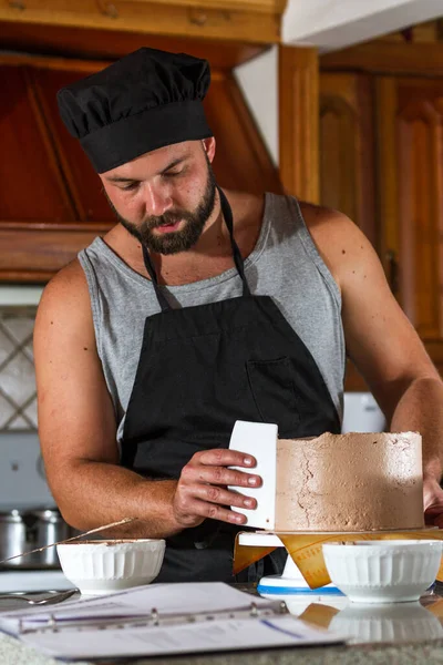 Erkek Fırıncı Taze Bir Doğum Günü Pastasına Çikolata Kreması Sürüyor — Stok fotoğraf