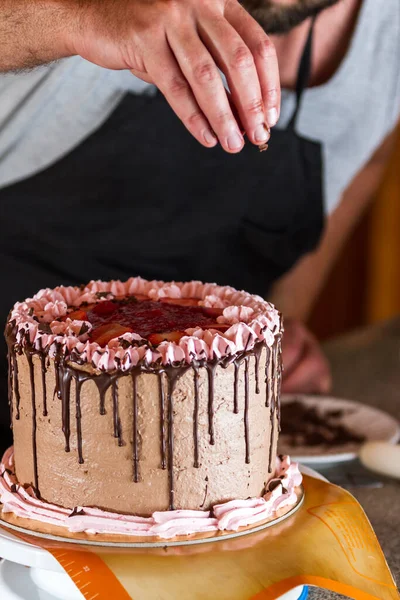 Man Bagare Dekorera Choklad Födelsedagstårta Med Jordgubbe Älg Glasyr Och — Stockfoto