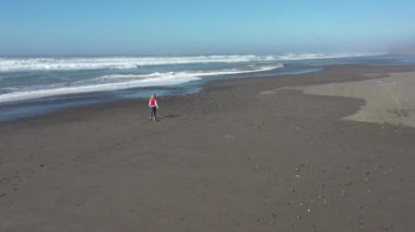 Kumsalda gezen bir kadın hazine ve cilalanmış taşlar arıyor ve Gold Beach Oregon 'da her zaman popüler olan
