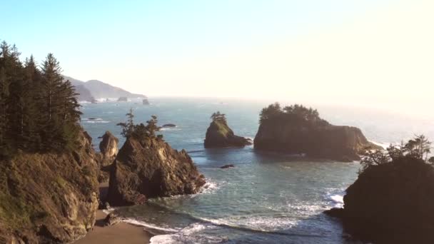 オレゴン州南部の海岸にある秘密のビーチの有名な島や岩の特徴に柔らかい光で美しい午後 — ストック動画