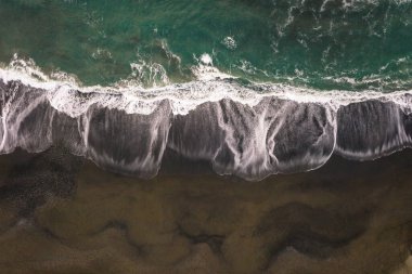 Güneşli bir günde kumların içinde ve dışında hareket eden dalgalar farklı bir bakış açısı ve huzur ve sükunet hissi sunar.
