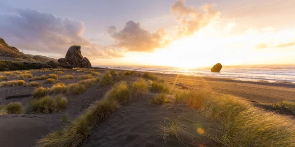 Beautiful afternoon in the southern Oregon Coast with the setting sun adding light and color to the clouds and a bit of reflected light on the tall grass