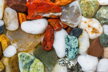 Oregon sahilinde çeşitli renkler ve şekillerde bulunan doğal cilalanmış küçük taşlara yakın durun.