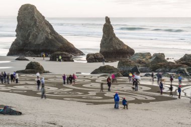 Bandon by the Sea, Oregon / USA - 21 Şubat 2020: Circles in the Sand ekibi tarafından yapılan bir labirentte yürüyen insanlar. Hareket eden bir kavram için yavaş deklanşör hızı.