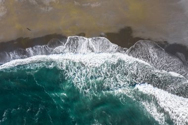 Güney Oregon Ocast 'taki kumla harmanlanan renkli dalgaların hava manzarası.