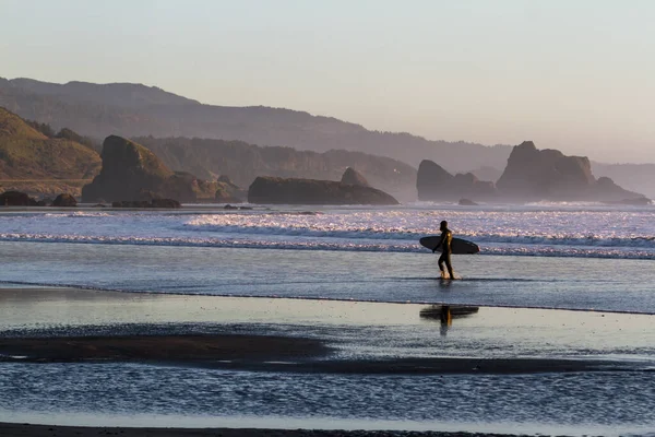 Muž Suchém Obleku Kráčí Mokrém Písku Surfovací Prkno Jak Slunce — Stock fotografie