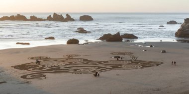 Bandon by the Sea, Oregon / USA - 20 Şubat 2020: Face Rock State Park 'ın düz kumlu plajında Circles in the Sand ekibi tarafından yapılan labirentte yürüyen insanlar
