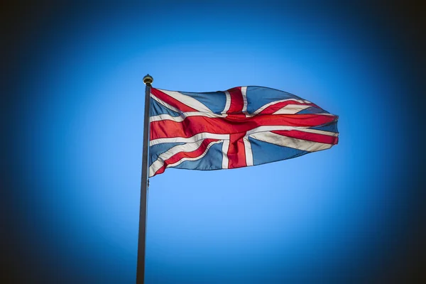 Reino Unido Union Jack bandeira que voa contra o céu azul — Fotografia de Stock