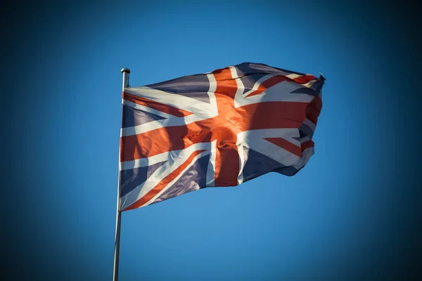 Union Jack i solljus mot klar blå himmel — Stockfoto